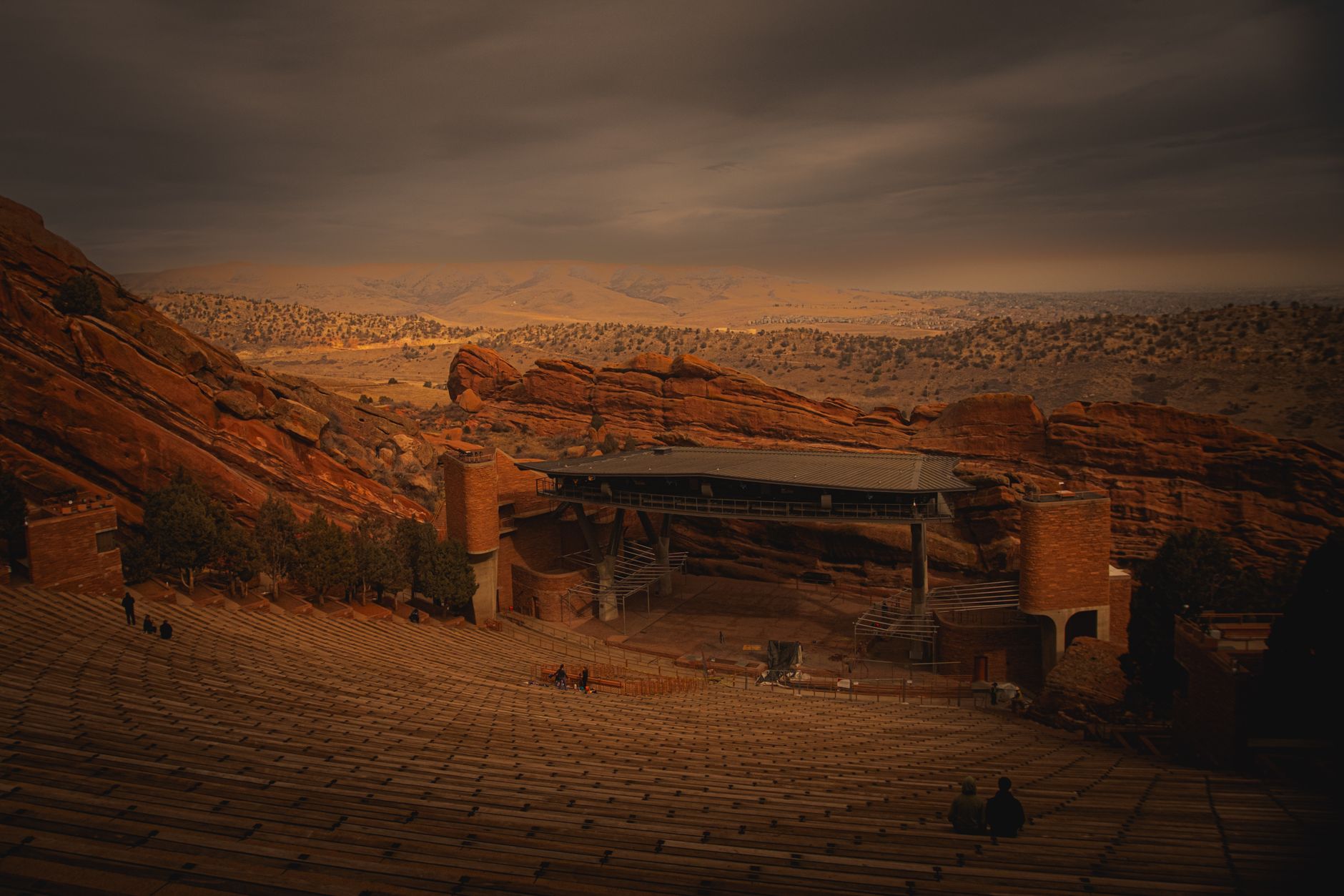 Red Rocks Amphitheatre amidst dramatic reddish rocks under an evening sky.